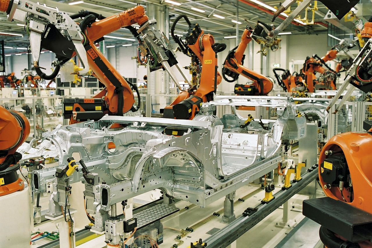 Industrial robot arms working together on a car production line.