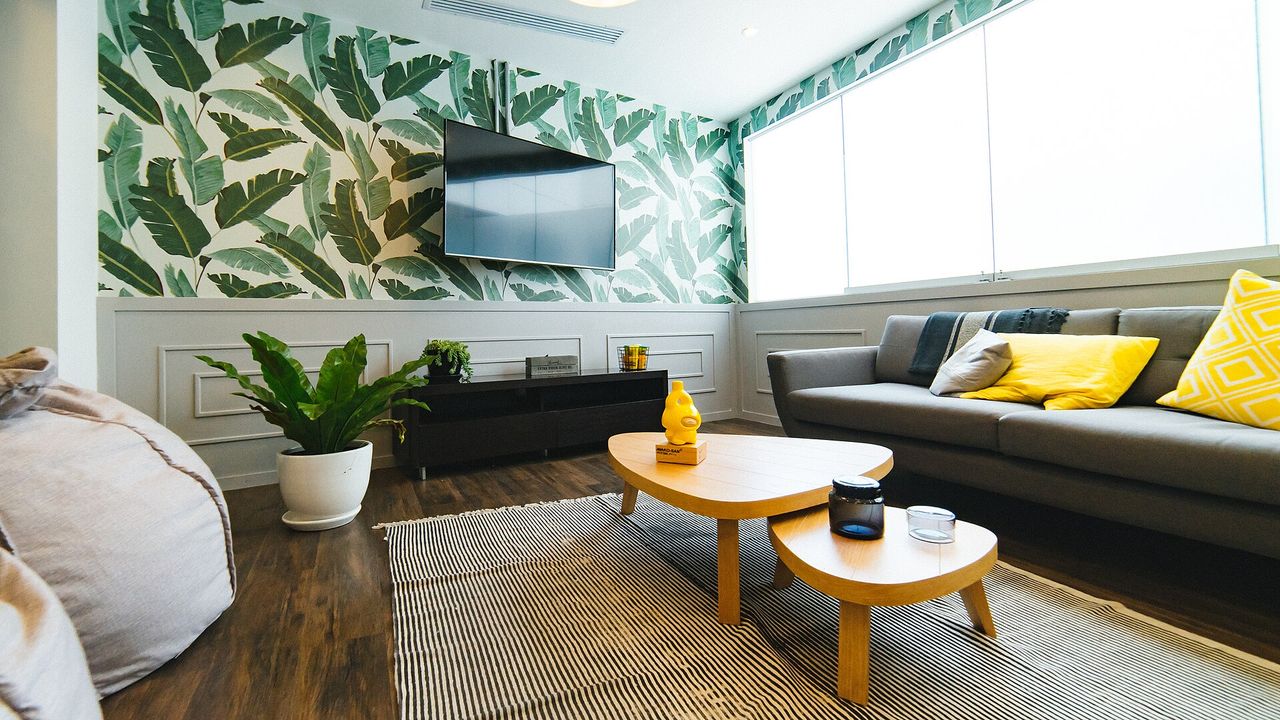 Co-working lounge with sofas, screens and round tables for sharing ideas.