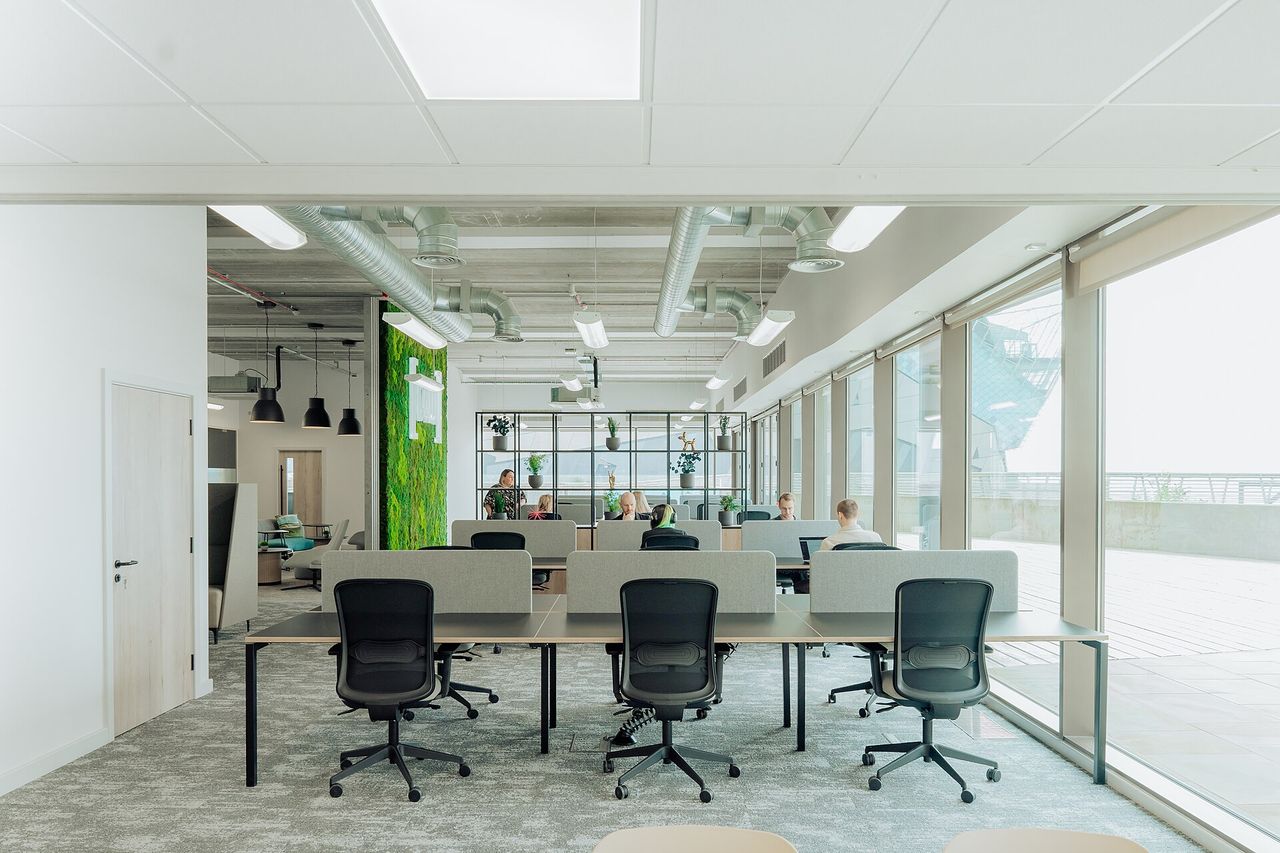 Bright co-working space with desks, a discussion area and glass partitions.