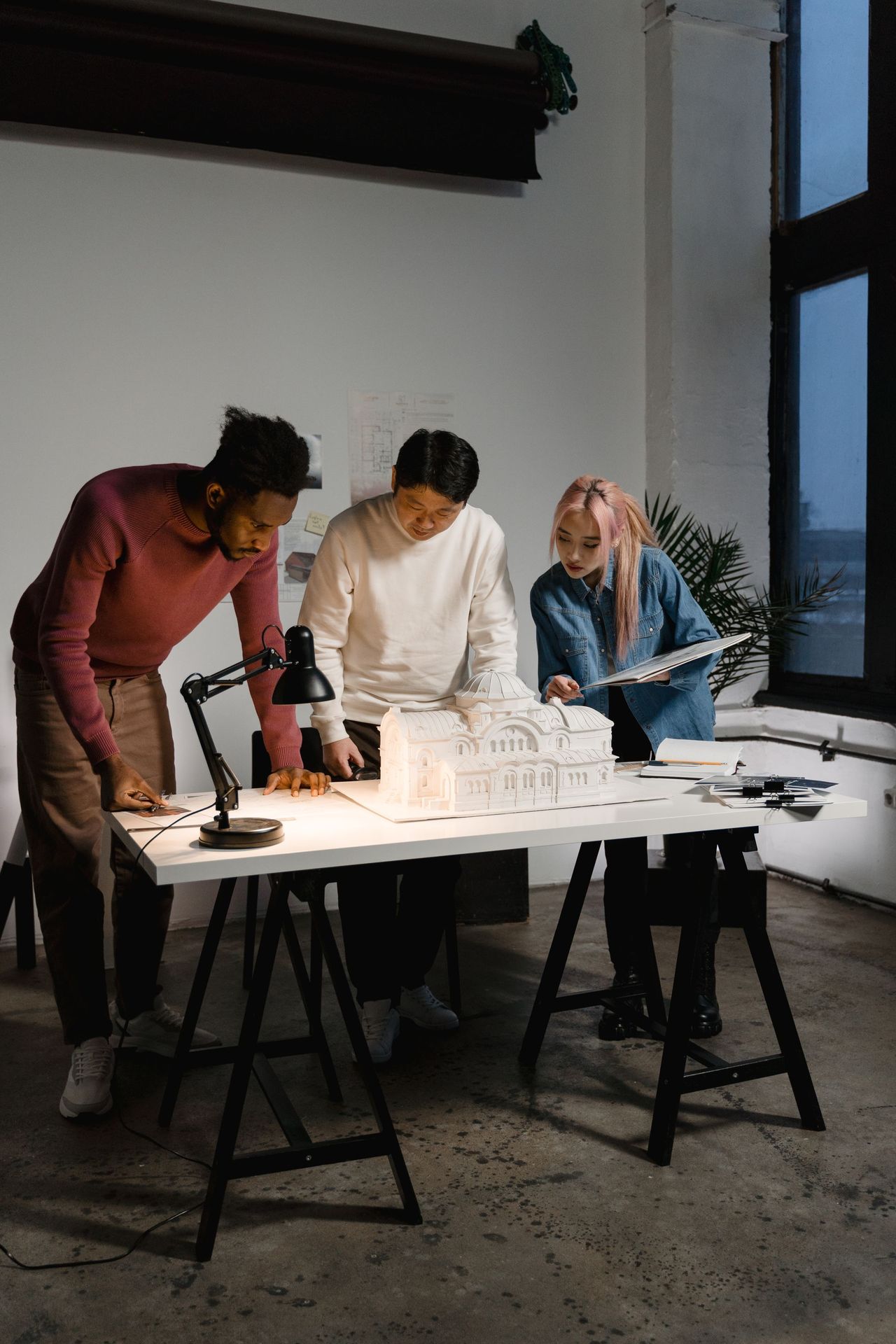 A group of experts discussing ideas around models and research documents in a workspace.