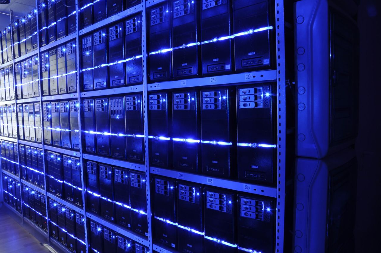 Rows of server racks lit in blue, illustrating infrastructure for information security practice.